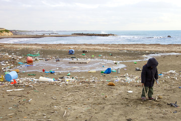 Young kid not caring about dirt and danger of polluted beach