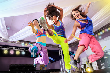 young women in sport dress jumping at an aerobic and zumba exerc - obrazy, fototapety, plakaty