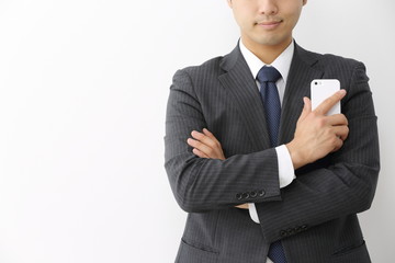スマートフォンを持って悩むビジネスマン