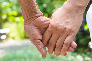 Senior and young holding hands