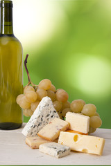portions of cheese with white wine bottle