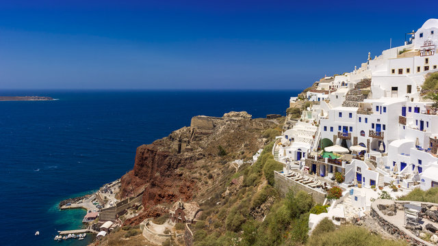 white houses and old  fortress on the red rock . Santorini.