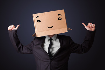 Businessman gesturing with a cardboard box on his head with smil