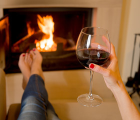 woman drinking wine in front of fire