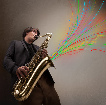 Attractive musician playing on saxophone while colorful abstract