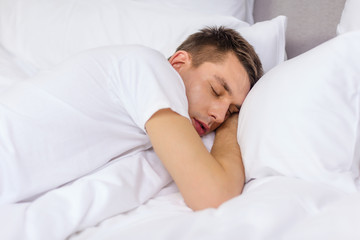 Obraz na płótnie Canvas handsome man sleeping in bed