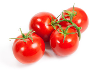three fresh tomatoes with green leaves isolated on white backgro
