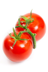 three fresh tomatoes with green leaves isolated on white backgro