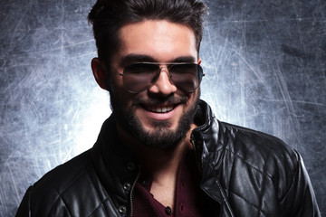 young man with long beard and sunglasses smiling