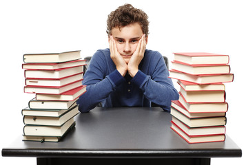 Hopeless student with face in hands sitting at his desk between