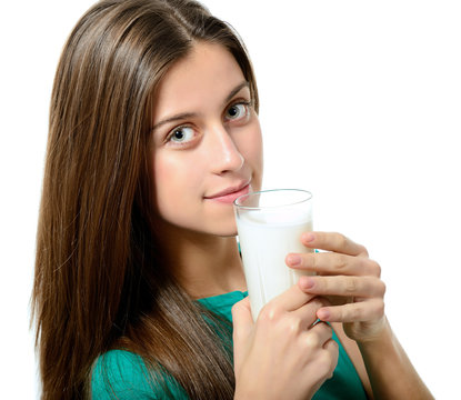 portrait of beautiful cheerful teen girl drinkink milk over whit