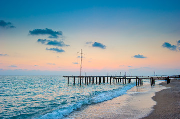 Fototapeta na wymiar frame of the old pier on the beach at dawn