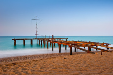 Obraz premium zardzewiały szkielet starego molo i turkusowego morza