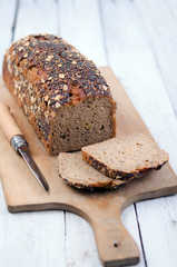 K&ouml;rnerbrot auf Holzbrett mit Messer