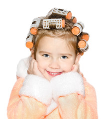 Portrait of smiling cute little girl in hair curlers and bathrob