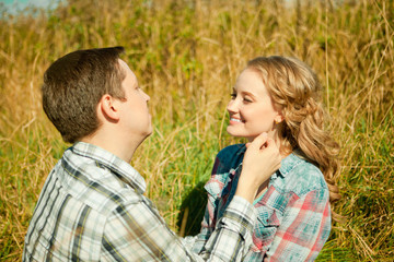 Happy young adult couple in love on the field. Two,  man and wom