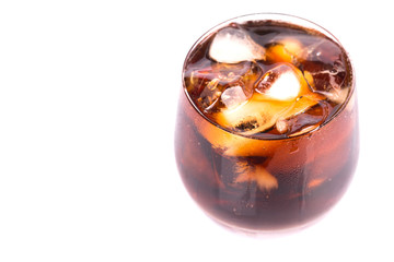 Cola drink with ice cubes in a short glass over white background