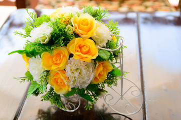 beatiful plastic bouquet of flowers on wooden table