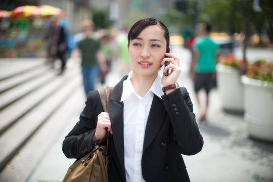 Asian business woman in New York City on cellphone