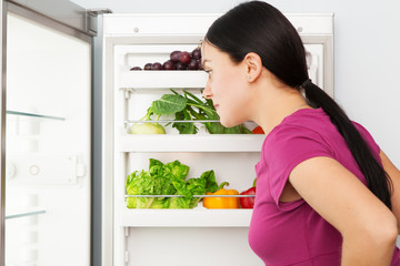 Young woman looking into a refrigerator