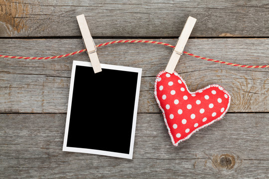 Blank instant photo and red heart hanging on the clothesline