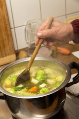 Senior beim Suppe kochen