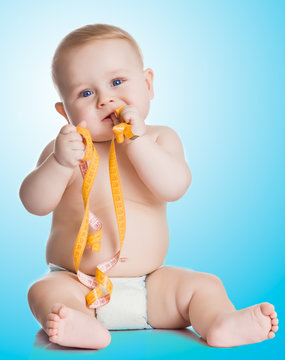 Adorable Baby Boy with a measuring tape on blue background