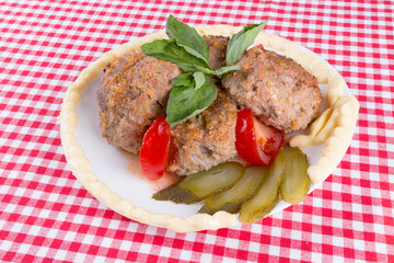 lula lamb and tomato on a plate on the table