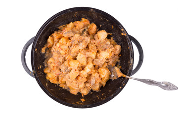 stewed potatoes with meat in a cast iron bowl