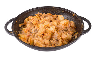 stewed potatoes with meat in a cast iron bowl