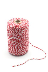 Red and white baker's twine spool isolated on white background