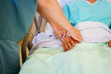 Obraz na płótnie Canvas Nurse adjusting intravenous tubing