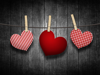 hearts hanging on clothesline over wooden background