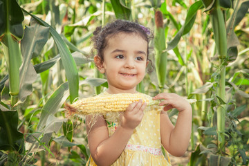 Beautiful small girl in the corn farm