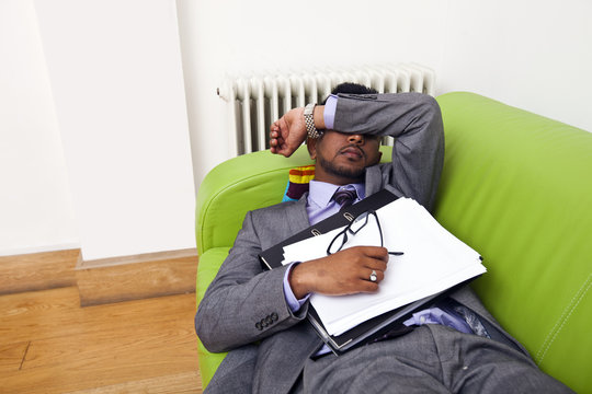 Businessman sleeping on a sofa - Powered by Adobe