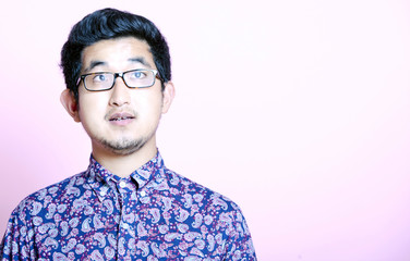 Fototapeta premium Young Geeky Asian Man in colorful shirt wearing glasses