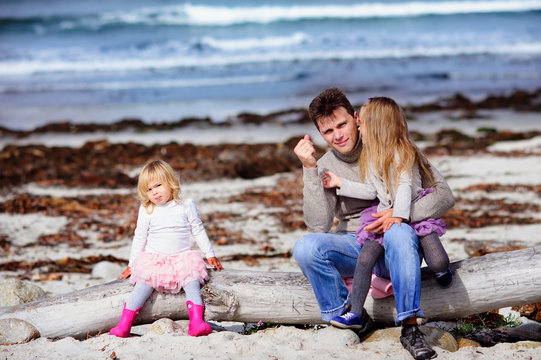 portrait happy young family in casual fashion wear on a sandy be