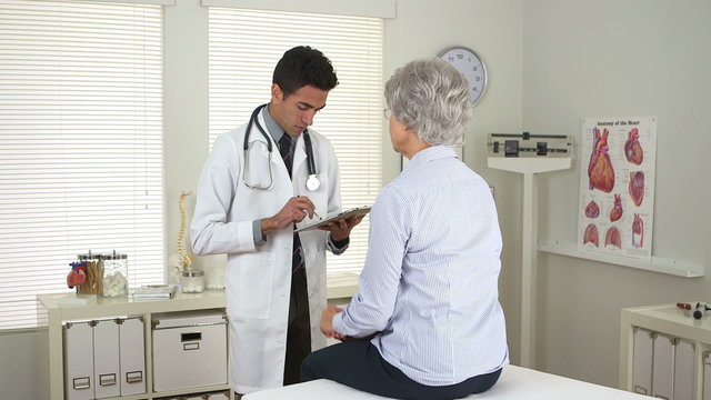 Hispanic doctor taking notes on tablet