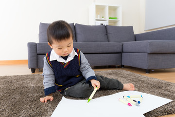 Asian little boy drawing picture at home