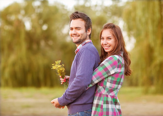 Fototapeta premium Young couple in love walking in the autumn park near the river.