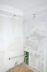 Room renovation. Gypsum plasterboard with undone socket bulbs.