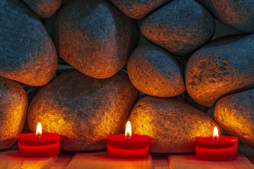 Candles are lit on the background of the sauna stones. Preparing
