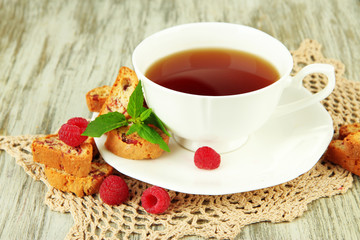 Cup of tea with cookies and raspberries on table close-up