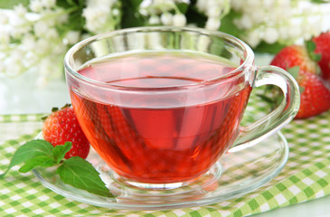 Delicious strawberry tea on table close-up