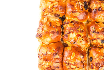 Homemade sweet bun with almond and raisins on a white plate