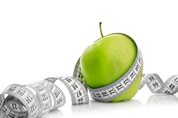 Measuring tape wrapped around a green apple