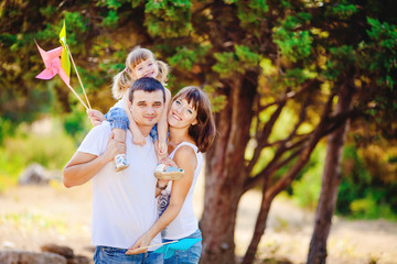 Fototapeta premium Happy young family with child resting outdoors in summer park
