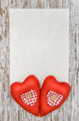 Valentine card with textile hearts on old wood
