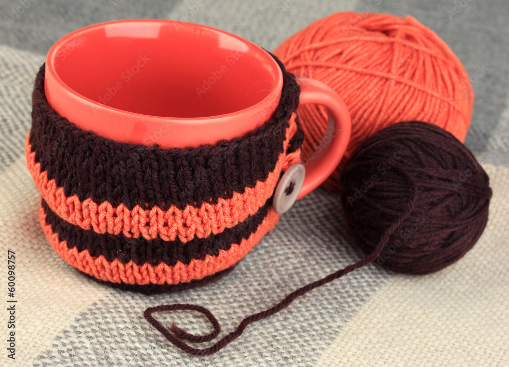 Aufkleber cup with knitted thing on it close up