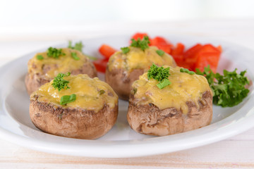 Stuffed mushrooms on plate on table on light background